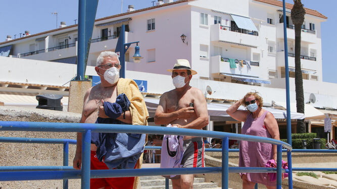 Bañistas con mascarillas en la playa de La Barrosa a mediados del pasado julio.