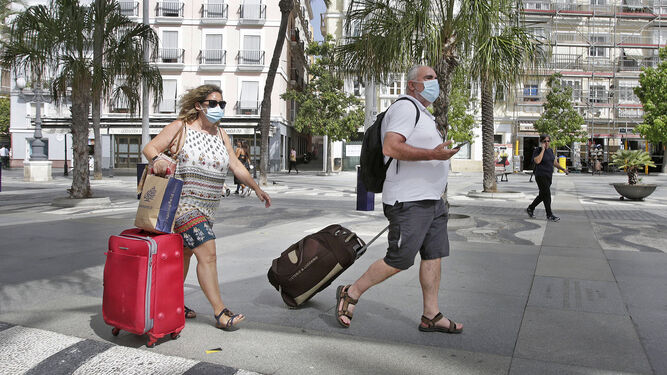 Turistas en Cádiz capital con maletas y mascarillas.