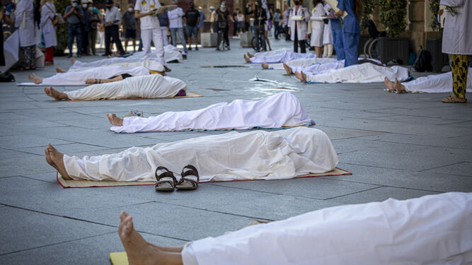 Imagen de los 'cadáveres' en el suelo en la acción simbólica por la salud y el clima.
