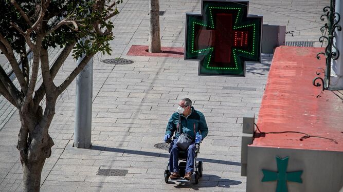Un hombre transita en silla de ruedas por la calle Real.
