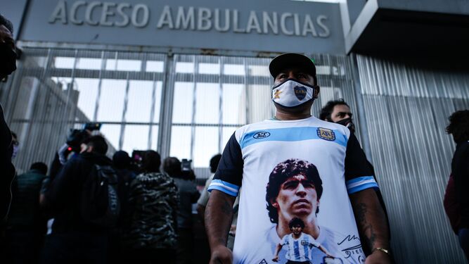 Un hincha muestra la efigie de Maradona ante la clínica donde pasa el postoperatorio.