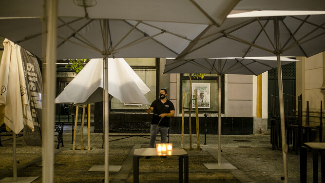 22:05, Un trabajador recoge la terraza de un restaurante en la Plaza de San Agust&iacute;n.&nbsp;