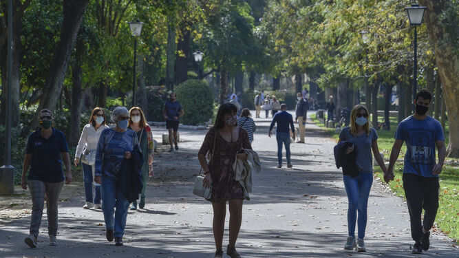 Un grupo de personas pasen por la calle con mascarillas.