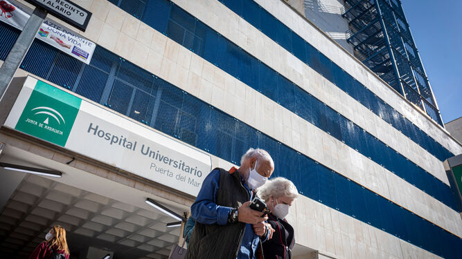 Dos personas salen del hospital Puerta del Mar.