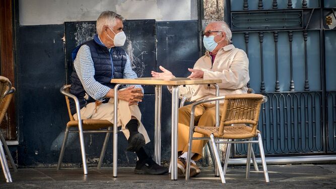 Dos personas charlando con su mascarilla en Cádiz.