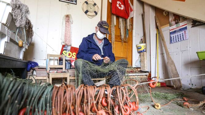 Un pescador con sus aperos en una de las casetas de La Casería.