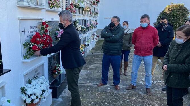 El alcalde, Antonio Cepero, coloca un ramo de rosas en el cementerio de la localidad.