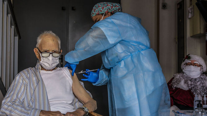 Un anciano es vacunado de covid.