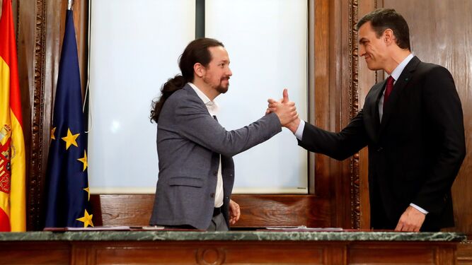 Pedro Sánchez y Pablo Iglesias estrechan sus manos tras el acto de firma del acuerdo programático en diciembre de 2019.