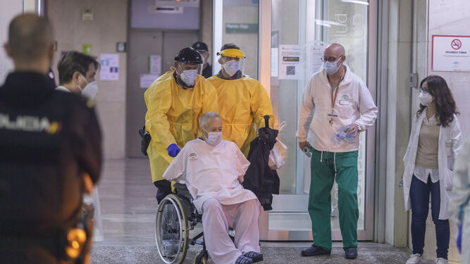 Andrés y José, con la protección EPI, trasladan al ya detenido tras provocar el incendio en el hospital.