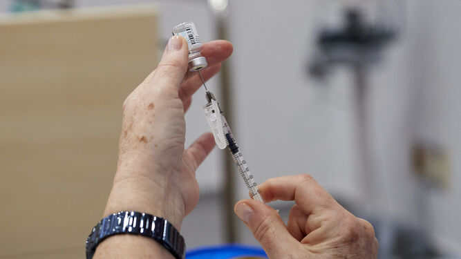 Un sanitario a punto de administrar una vacuna