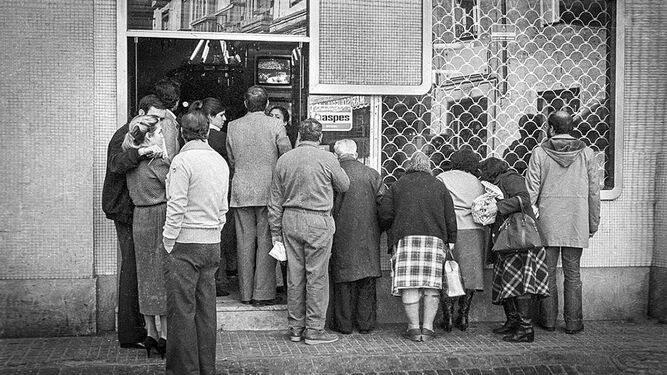 Varias personas se agolpan en un comercio de la plaza de San Agustín, en Cádiz, para seguir los últimos acontecimientos políticos en España, en una imagen del 24 de febrero de 1981, el día siguiente al intento de golpe de Estado.