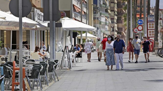 Varias personas pasean por el Paseo Marítimo de Cádiz.
