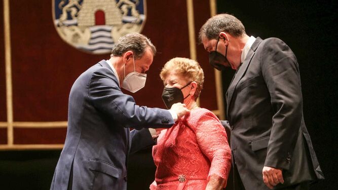 El alcalde le impone la insignia a Josefa Aragón, del bar 'El Poblaó',  acompañada de su hijo Domingo.