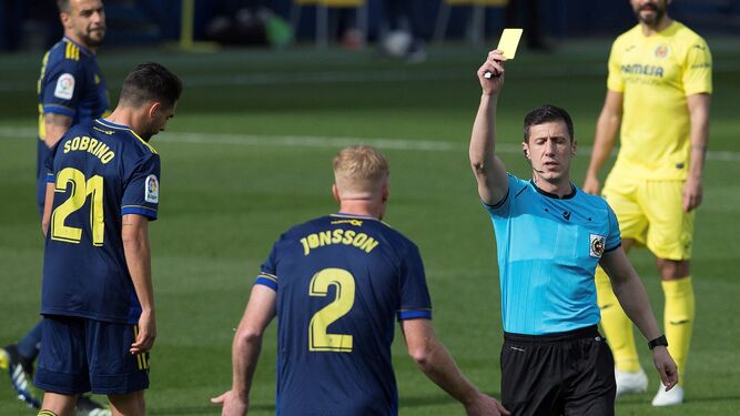 Soto Grado muestra tarjeta amarilla a Jonsson tras la mano que provocó el penalti del 1-0.