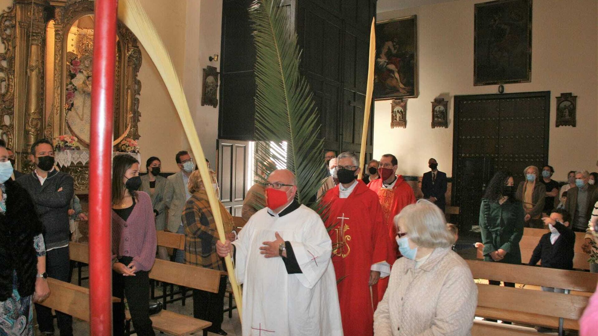 Los oficiantes de la misa de San Joaqu&iacute;n, durante la entrada al templo en la misa de Palmas de la hermandad de La Flagelaci&oacute;n.