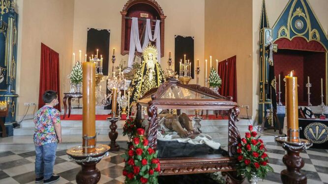 Un pequeño observa las imágenes del Santo Entierro y la Soledad en el interior de su capilla.