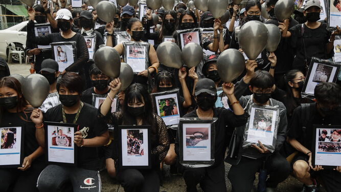 Manifestantes sostienen globos negros y fotos de las víctimas en la sentada de ayer en Rangún.
