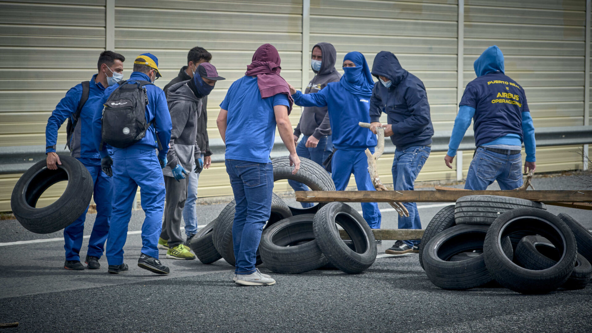 Trabajadores recopilando materiales para la construcci&oacute;n de barricadas.