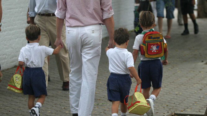 Un padre lleva a sus hijos a un centro concertado.