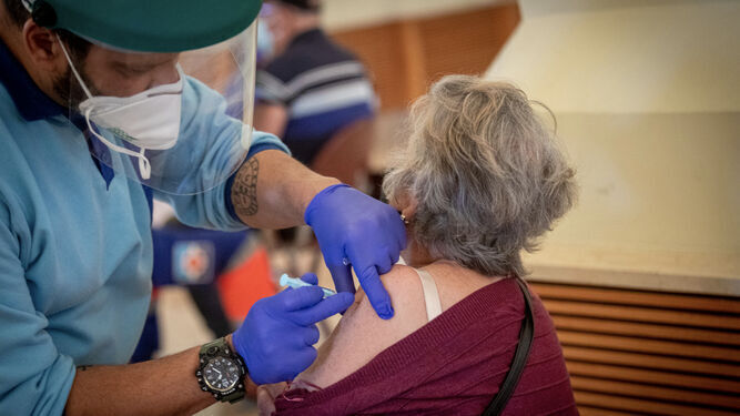 Un señora es vacunada en el Palacio de Congresos de Cádiz.