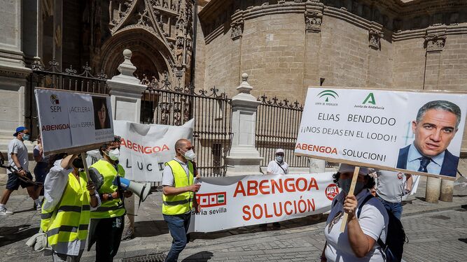 Trabajadores de Abengoa, durante una protesta, pasan por delante de la Catedral de Sevilla.