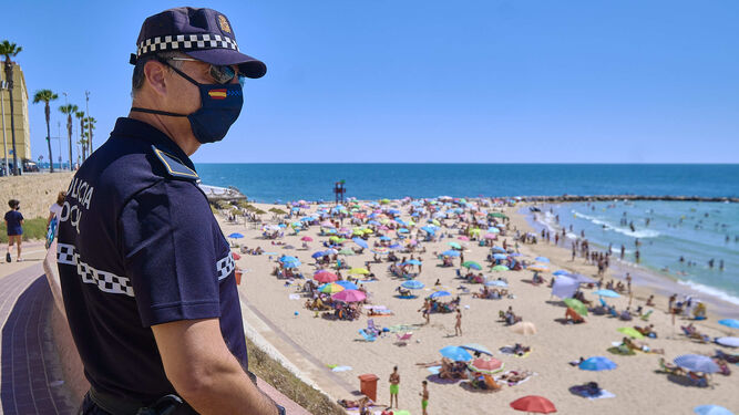 Un agente de la Policía Local vigila la playa de Santa María del Mar.