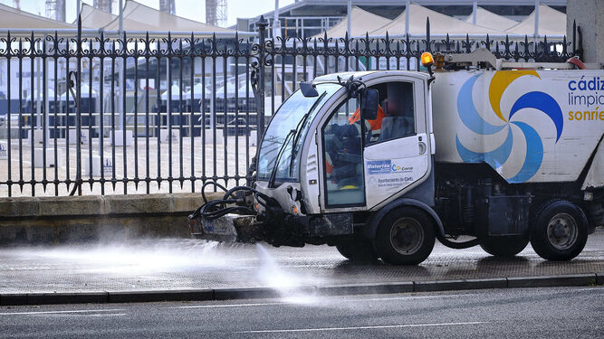 Un vehículo del servicio de limpieza baldea en la avenida del Puerto.