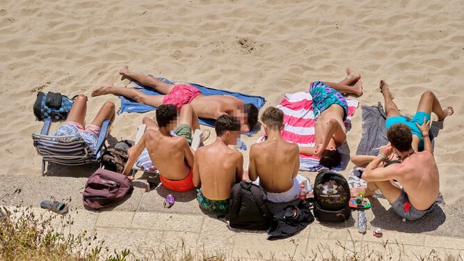Un grupo de jóvenes toma el sol en la playa Santa María del Mar.
