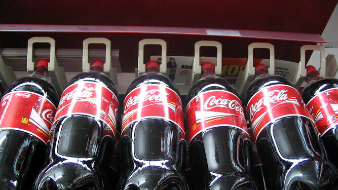 Estante con botellas  de litro de Coca Cola.