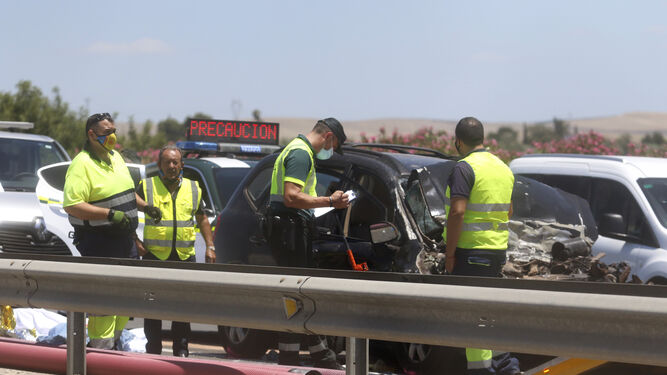 Agentes de la Guardia Civil y servicios de rescate junto al vehículo accidentado.