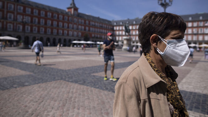 Una mujer con mascarilla, en la Plaza Mayor de Madrid, durante el último día en el que es obligatorio su uso en exteriores.