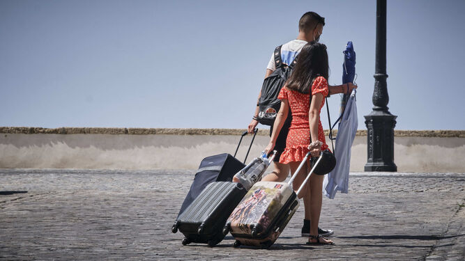 Una pareja de turistas, con sus maletas a cuestas, en la zona del Campo del Sur de Cádiz.