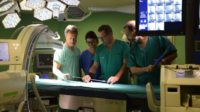 Tomás Daroca (izquierda) y Miguel Ángel Gómez (centro) con dos cirujanos que asistieron uno de los cursos sobre el procedimiento TAVI en un quirófano de Cirugía Cardíaca del Puerta del Mar.
