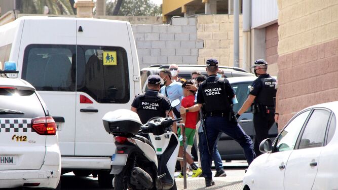 Varios agentes y vehículos de la Policía Local de Ceuta acompañando este viernes a menores no acompañados hacia una furgoneta. para su retorno a Marruecos.