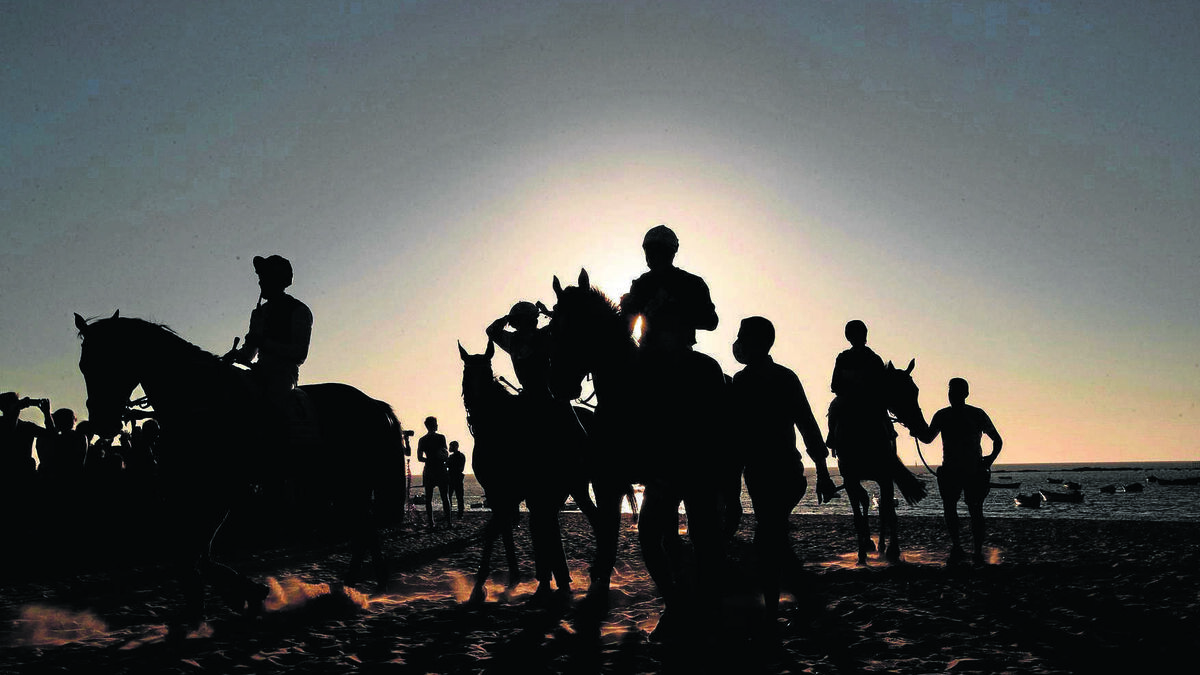 Fin de las pruebas del segundo día del primer ciclo, en el ocaso, de la 176ª edición de las carreras de caballos celebrada el pasado viernes en las playas de Sanlúcar de Barrameda.