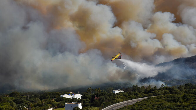Un avión del Infoca, intentando sofocar el incendio declarado este lunes en el término municipal de Tarifa.