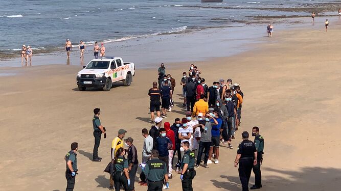 El grupo de migrantes ha sido custodiado por los agentes en la misma playa.