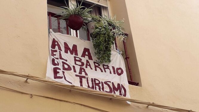 Una pancarta colgada en la ventana de una vivienda en el barrio de El Pópulo, de Cádiz.