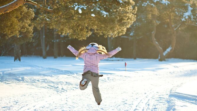 Una niña juega en la nieve con sus botas de invierno