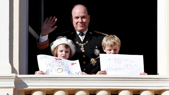 Alberto de Mónaco saluda desde el balcón del Palacio Grimaldi con sus hijos, quienes portan emotivos mensajes de recuerdo a su madre, Charlene.