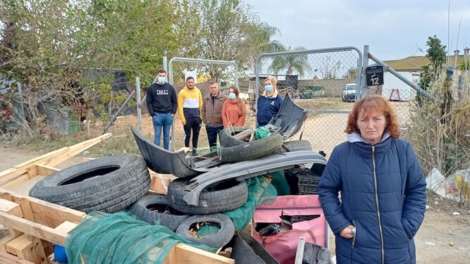 Rocío Becerra y su familia, junto a uno de los montones de residuos que cortan el acceso a su vivienda en señal de protesta.