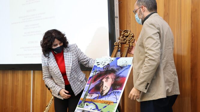 La consejera de Igualdad, Rocío Ruiz, descubriendo el cartel del 50 aniversario en presencia de su autor.
