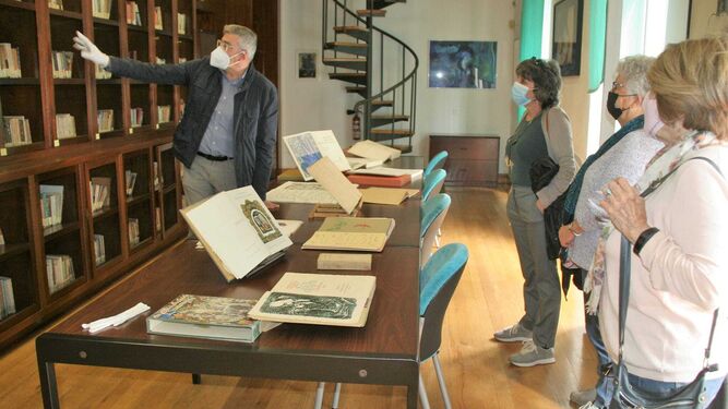 El trabajador de la Fundación Rafael Alberti, Enrique Pérez, mostrando la biblioteca a unas visitantes.
