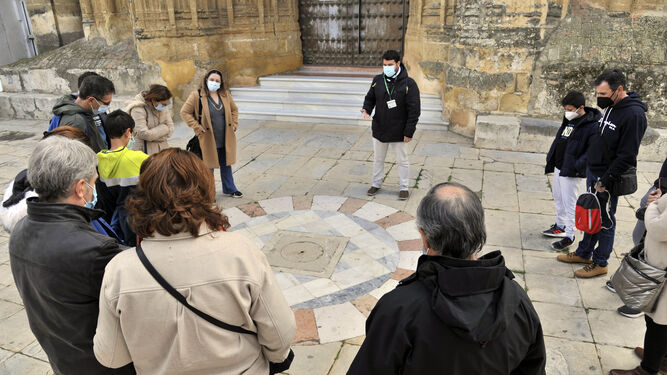 Un grupo de turistas atendiendo las explicaciones de un guía.