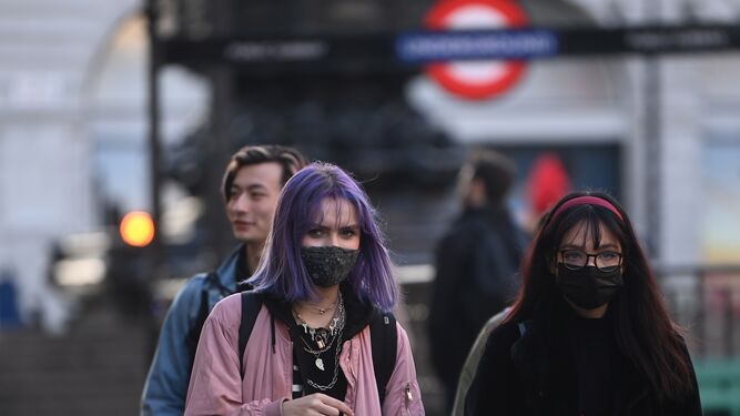 Un par de mujeres con mascarillas pasean por Londres