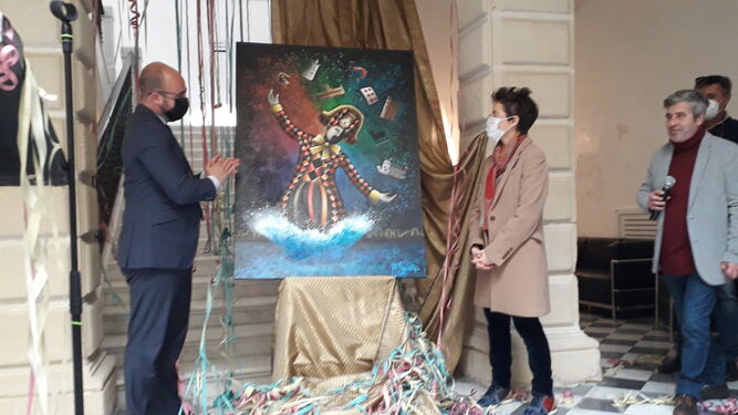 El alcalde y la autora del cartel, junto a la obra en presencia del presentador del acto, Riverita.