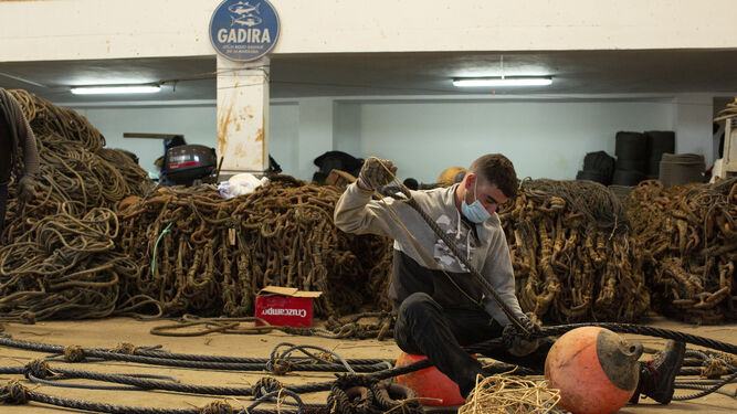 Uno de los trabajadores de la almadraba de Conil prepara en tierra las boyas que se calarán.