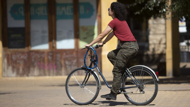 Una joven circulando en bicicleta por la ciudad.