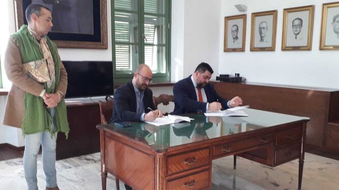 El alcalde y el presidente del Consejo firman el protocolo en presencia del concejal de Fiestas.